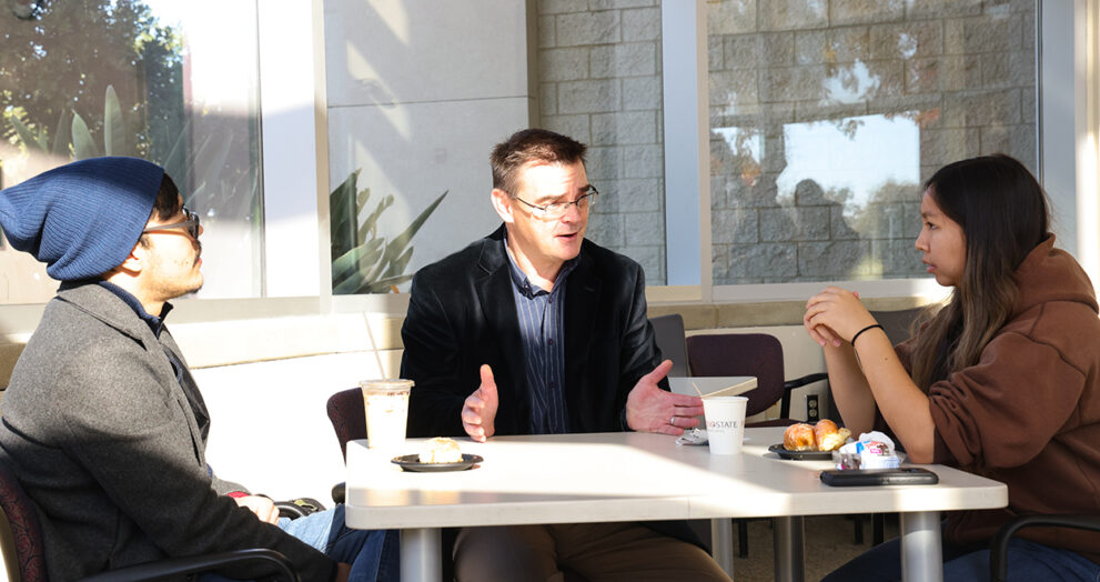 Dr. Jason Bush speaks with students during Donuts with The Dean event.